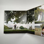 Fotolibro Premium Layflat abierto mostrando la apertura panorámica 180° con una foto de boda a doble página