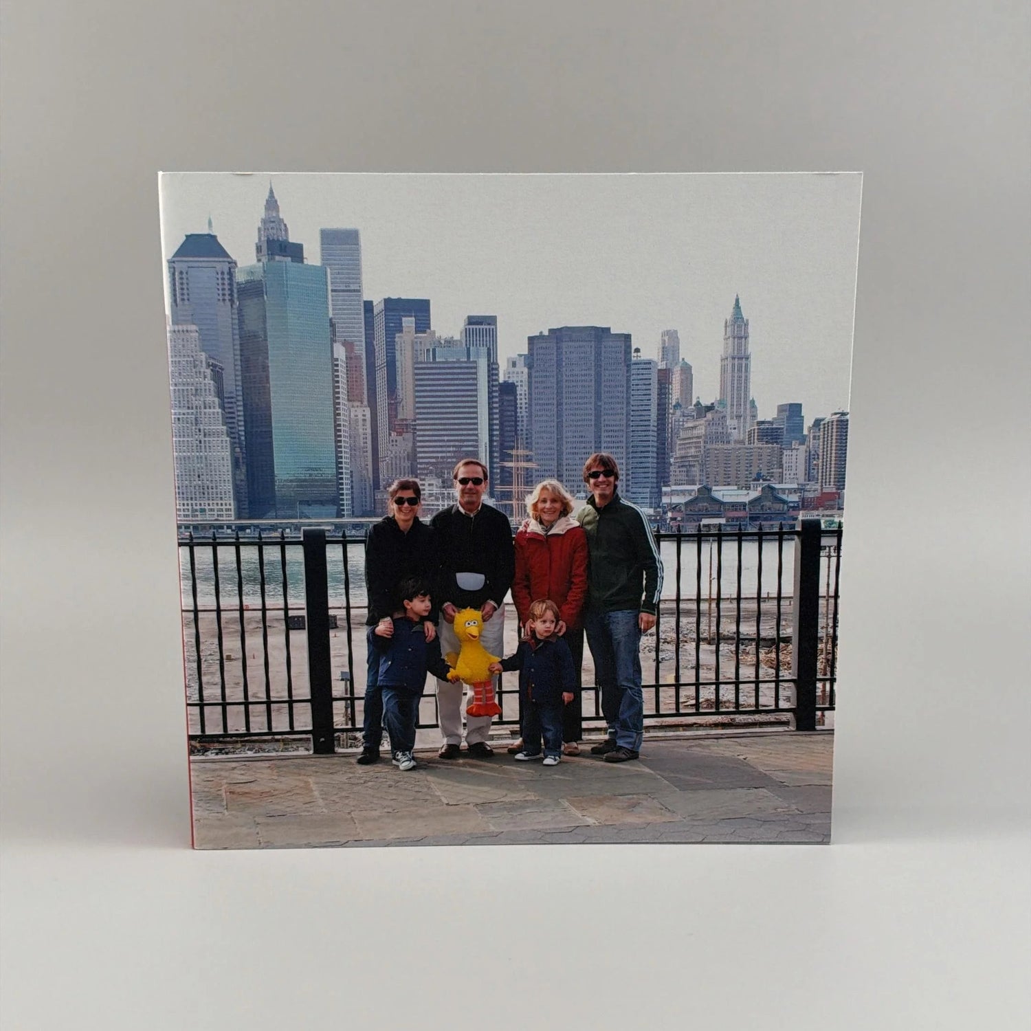 Fotolibro cuadrado con tapa al corte mostrando una familia frente al skyline de Nueva York