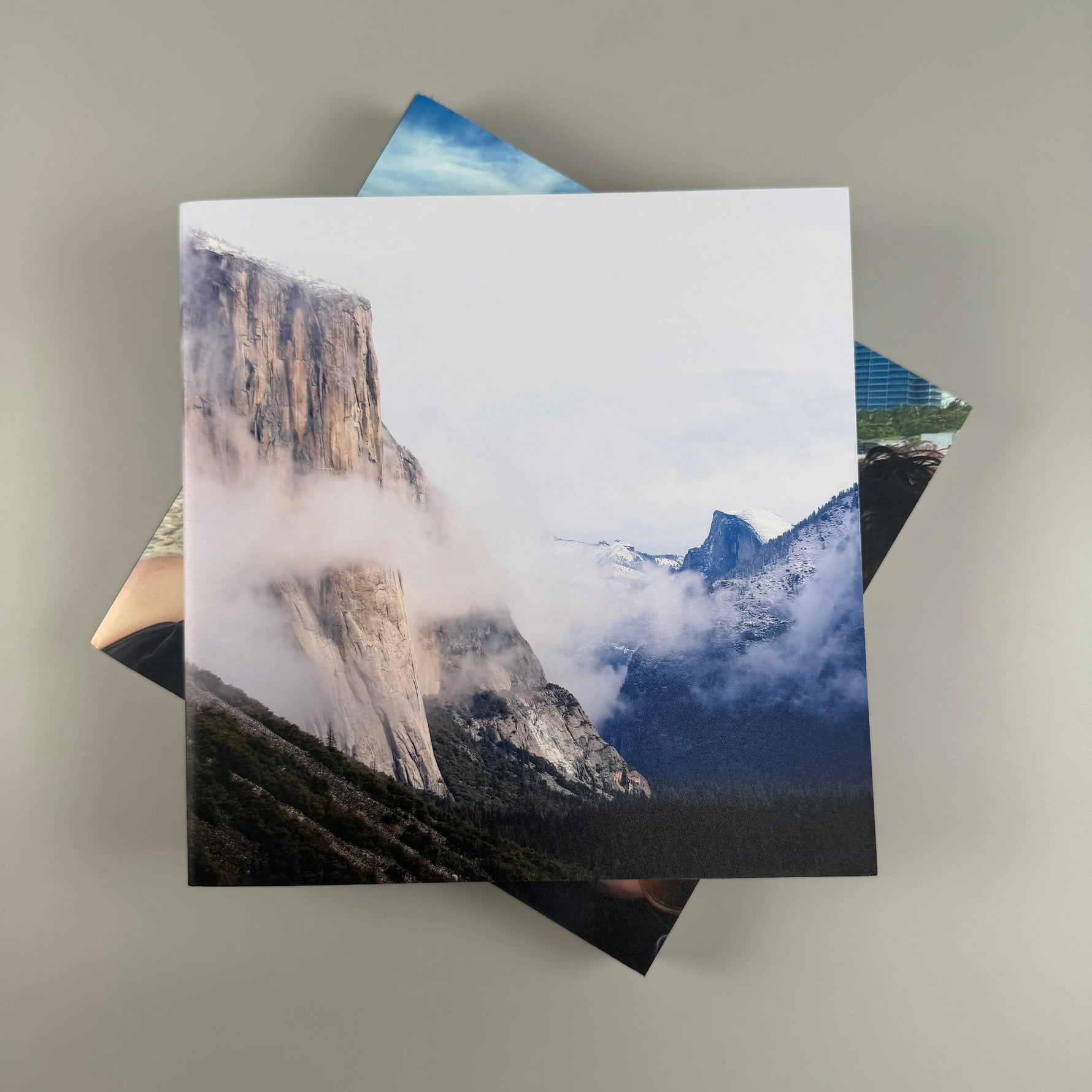 Fotolibro cuadrado con paisaje del valle de Yosemite entre nubes sobre la tapa