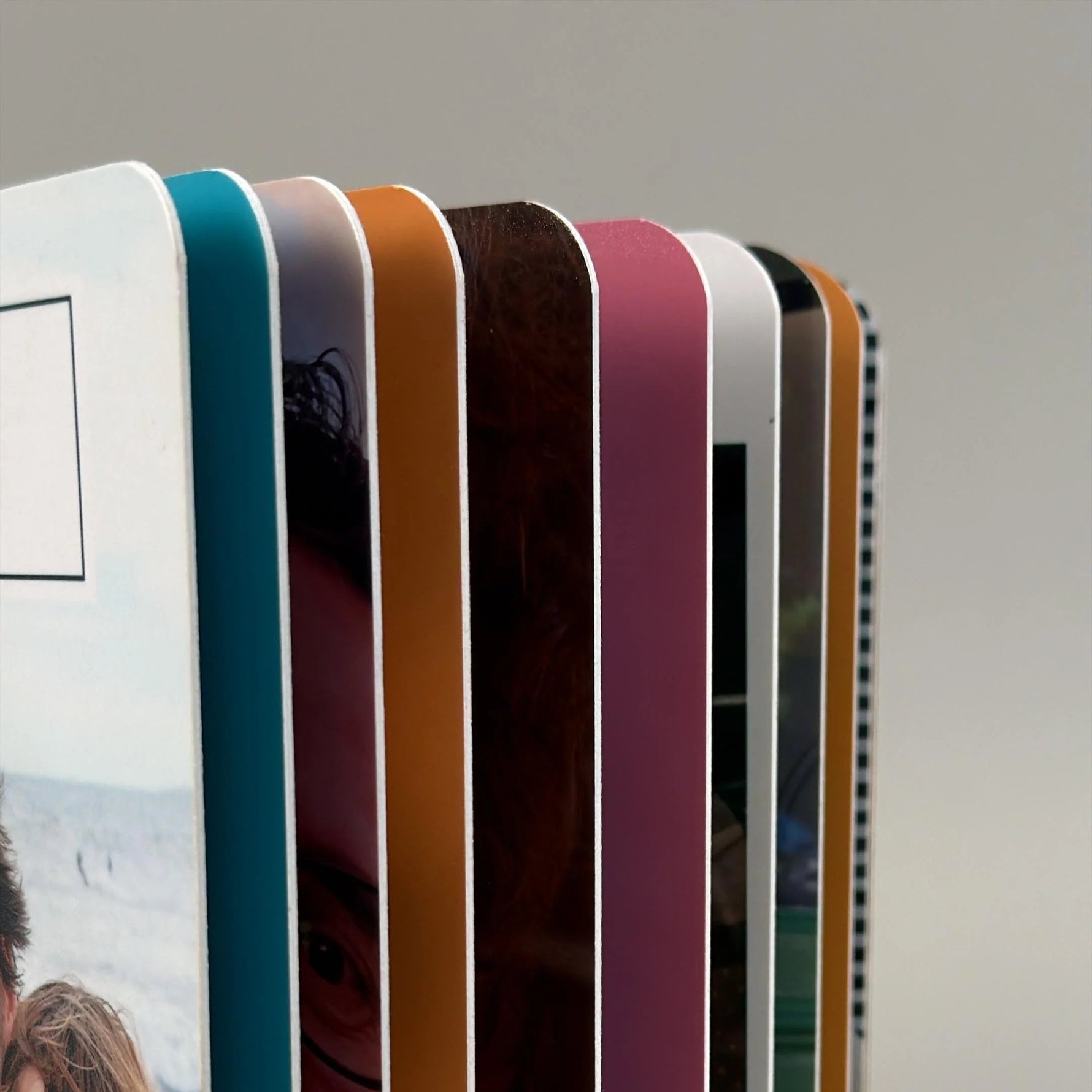 Detalle del lomo del fotolibro mostrando hojas gruesas de cartón con cantos de colores y esquinas redondeadas seguras