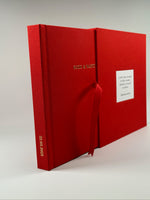 Fotolibro y estuche de lino rojo abiertos en abanico, con nombres en dorado y dedicatoria