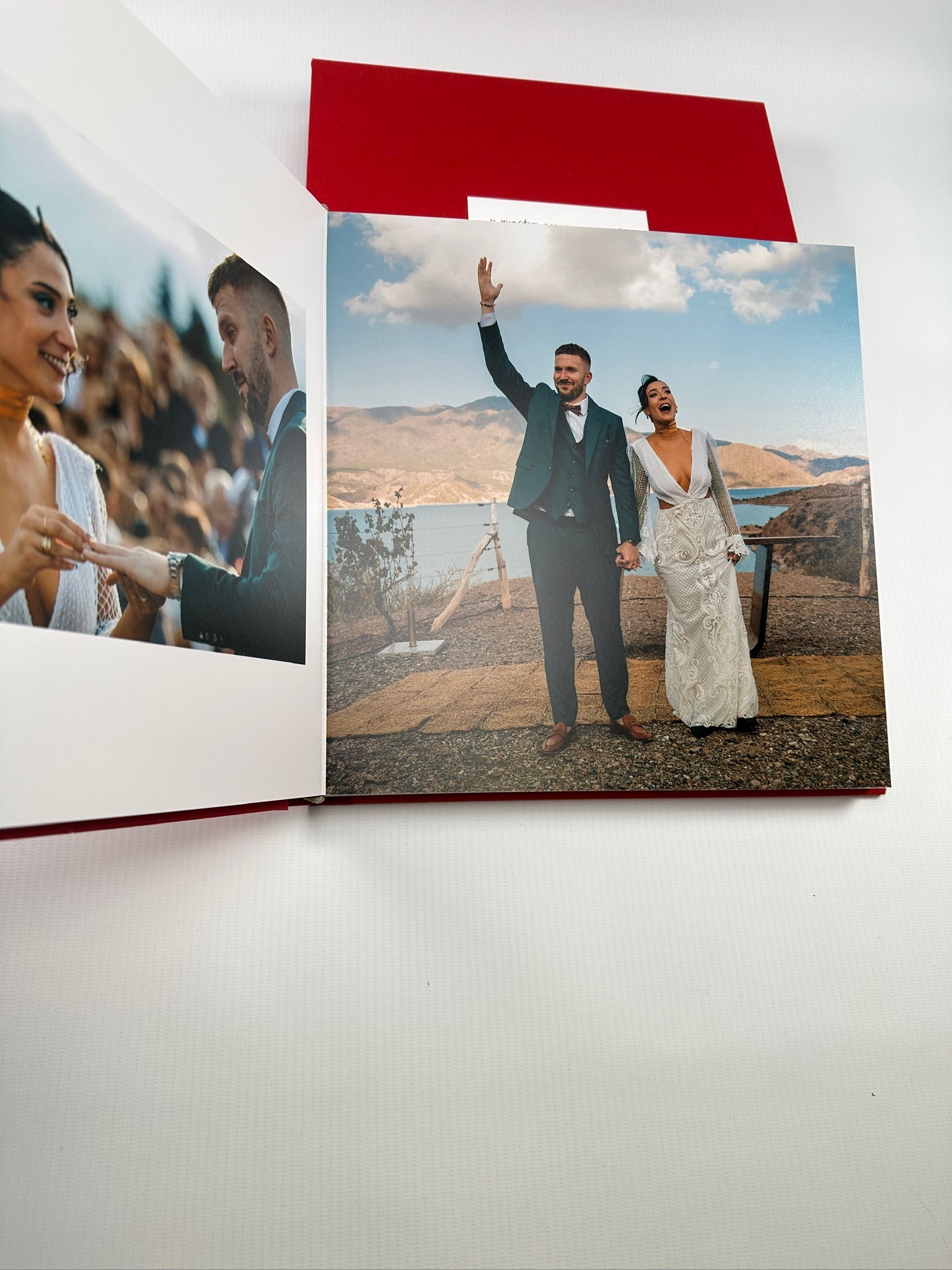Fotolibro de bodas abierto a doble página, los novios en una boda al aire libre frente a un lago