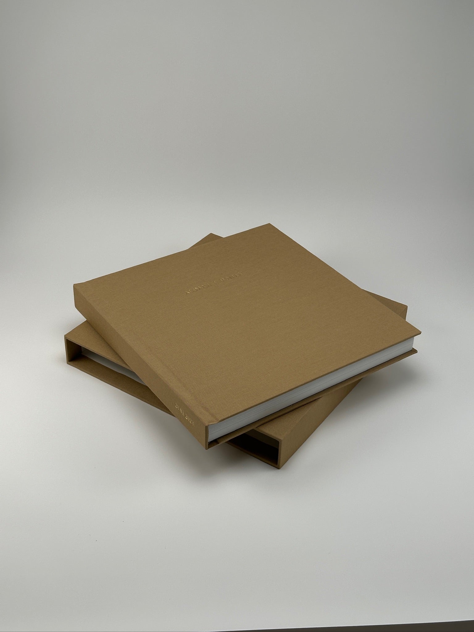 Fotolibro de lino camel con nombre en dorado adelante del estuche apaisado a juego