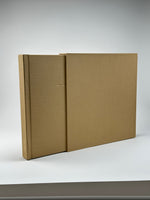 Vista angular del álbum camel saliendo de su caja de lino, con nombre grabado en dorado