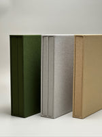 Estuches de lino verde, gris y avena de canto, mostrando la textura del lino en cada color