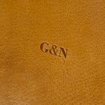 Primer plano del grano del cuero con las iniciales G&N grabadas en Hot Stamping